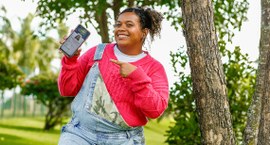 Eleitora segurando o celular com o e-Título em destaque